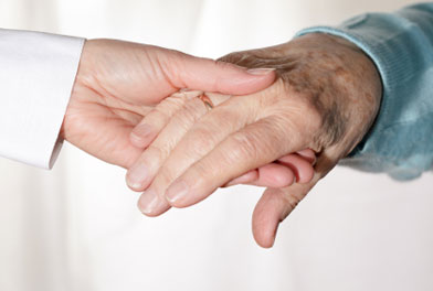 Image of young hand holding an elderly hand